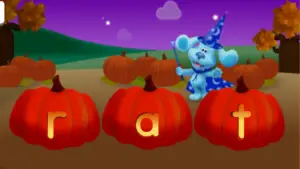 Screenshot of Blue from Blues Clues standing behind three pumpkins. Each pumpkin is carved with one letter, spelling the word RAT.